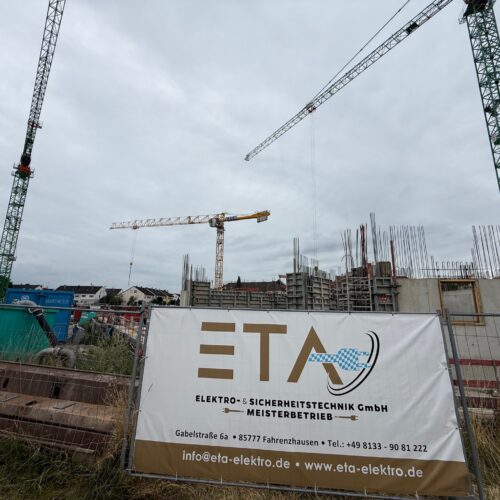 Eine Baustelle mit Kränen und einem Gebäude im Bau unter bewölktem Himmel