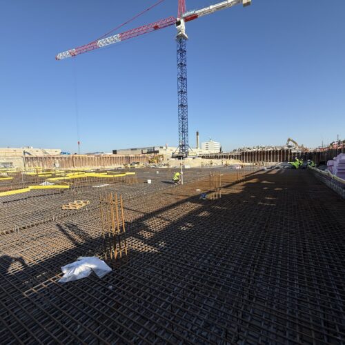 Eine Baustelle mit Stahlgerüsten, einem Kran und klarem Himmel.
