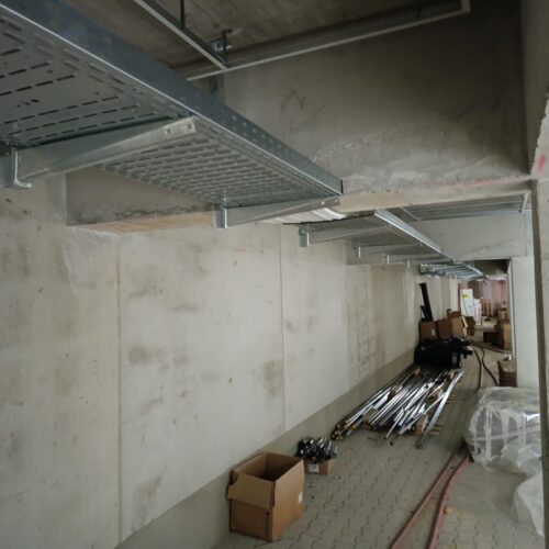 Ein  leerer  Kellerraum  mit  Metallkabeltrassen  an  der  Decke  und  verstreuten  Kartons