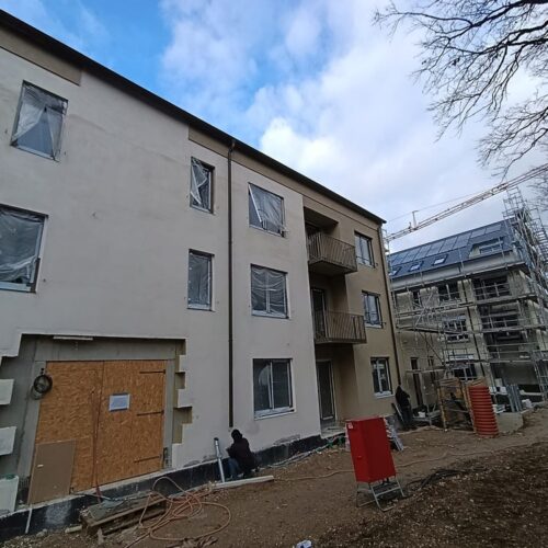 Zwei  Wohngebäude  im  Bau  mit  Gerüsten,  Baugeräten  und  Plastikfolie  an  Fenstern